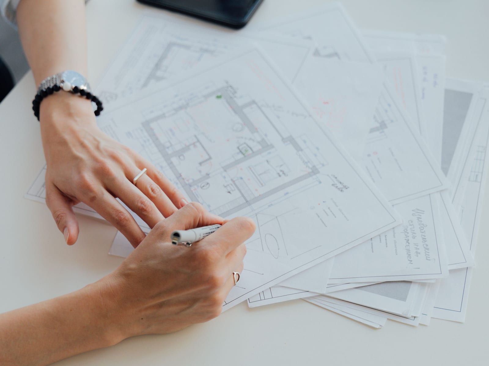 Hands working over technical drawings