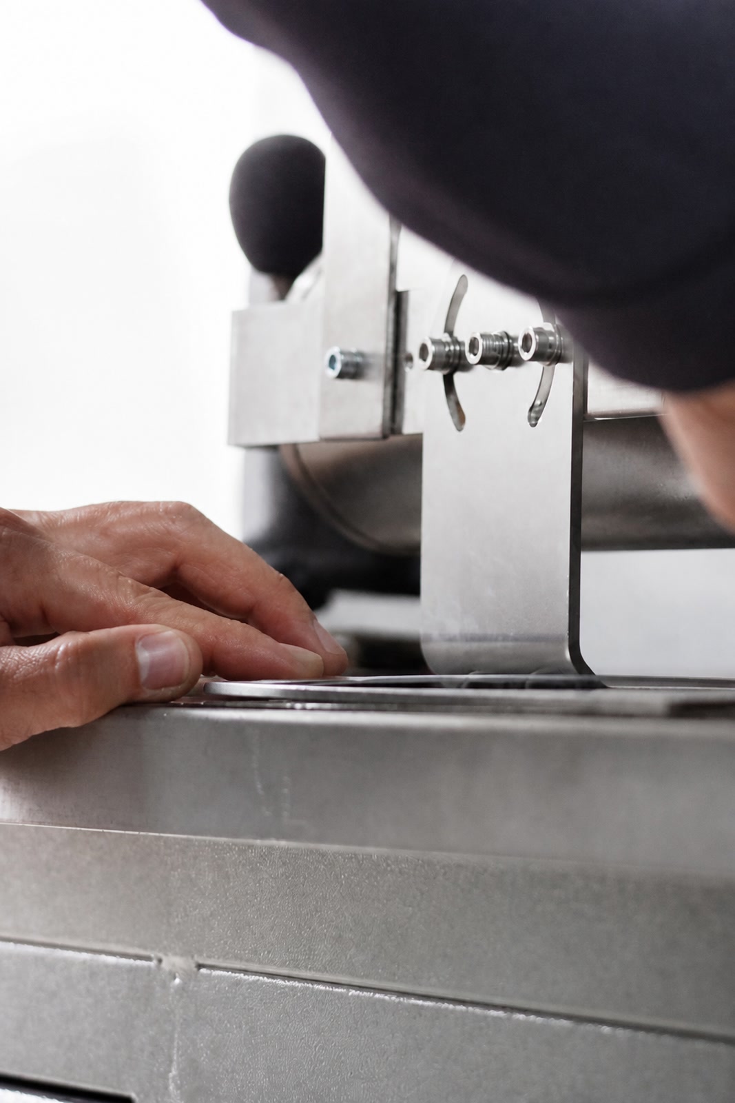 Hands adjusting an industrial machine